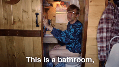 Guy in a bathroom that's also his home office;